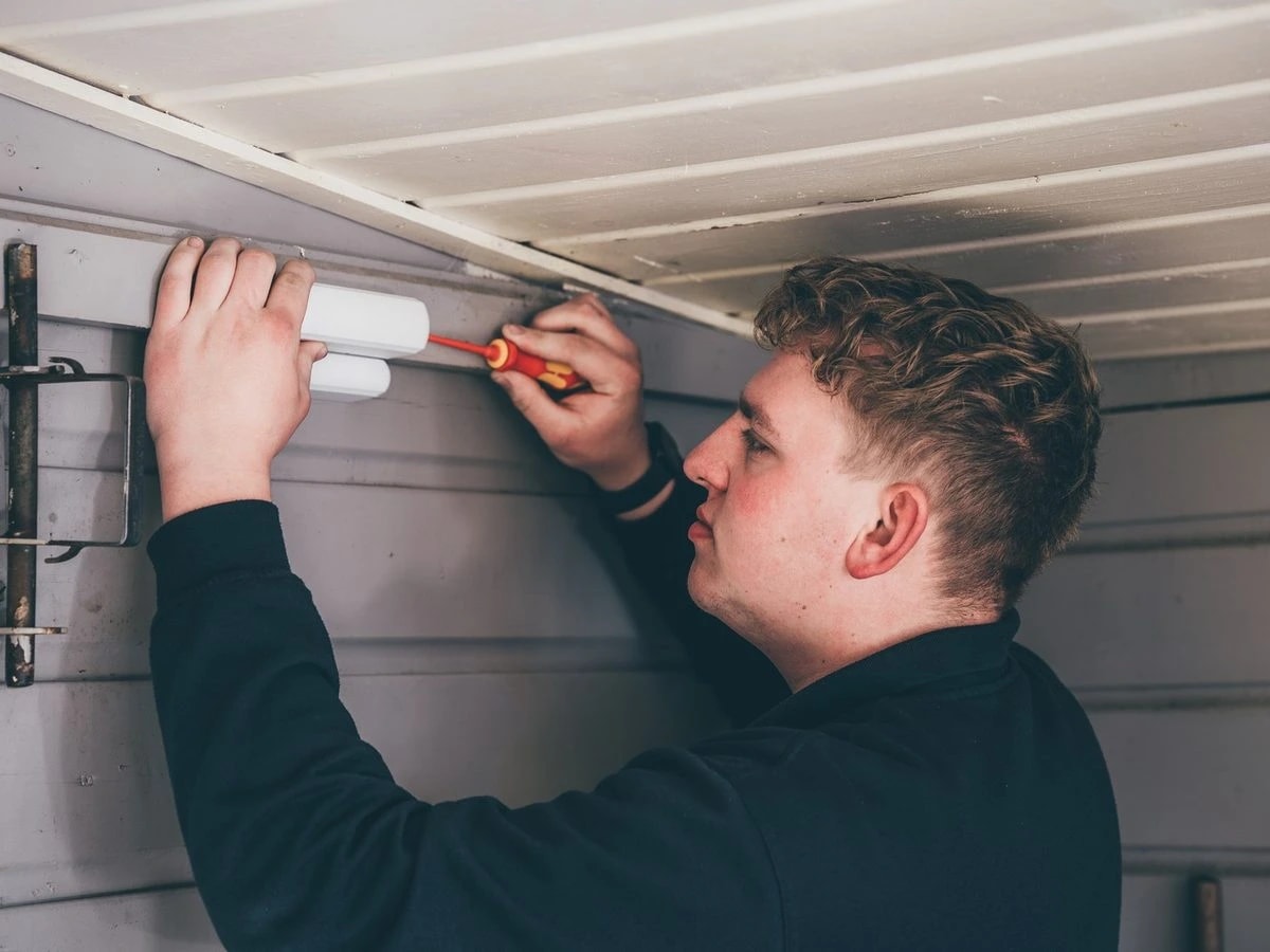 Robin Eefting installeert een Ajax magneetsensor op een deur